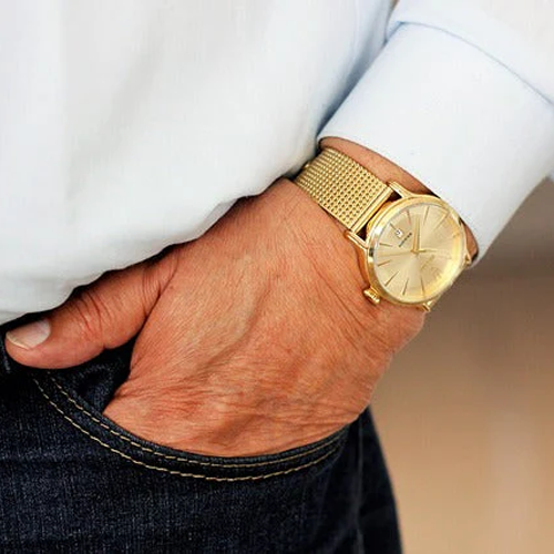 man-wearing-blue-jeans-and-a-gold-watch