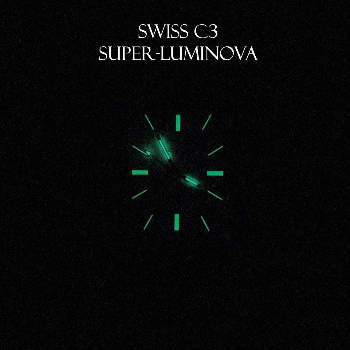 Momentum Harlingen automatic watch dial illuminated in the dark with Swiss C3 Super-Luminova, showing glowing green hands and hour markers.