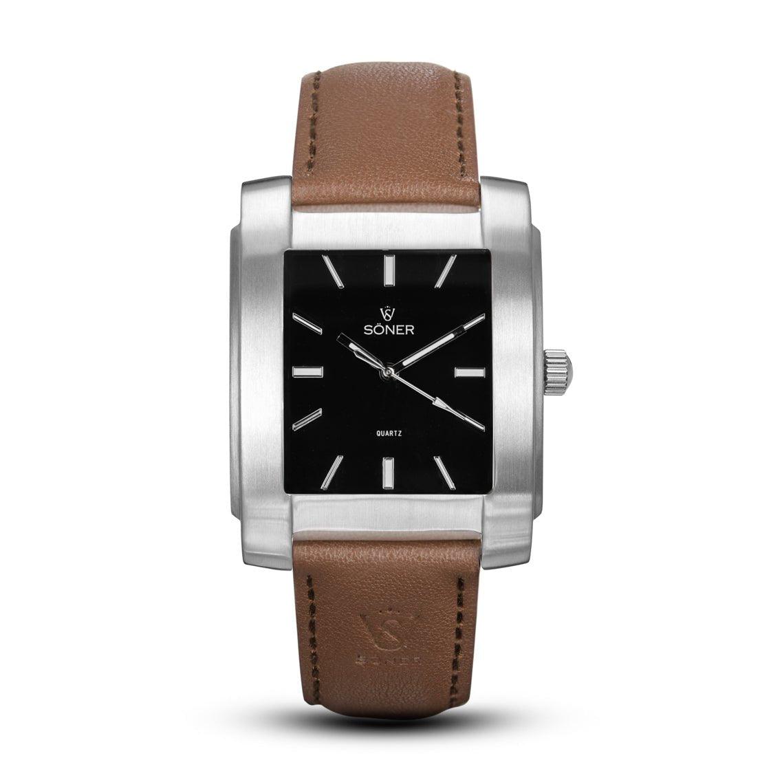 Introducing the Legacy Basilica watch, this elegant timepiece from Söner features a square silver case with a black face, highlighted by minimalist white hour markers and hands. It's complemented by a luxurious brown leather strap and subtly displays the name SONER on its sophisticated face. Plus, it offers a 3-year battery life for ongoing reliability.