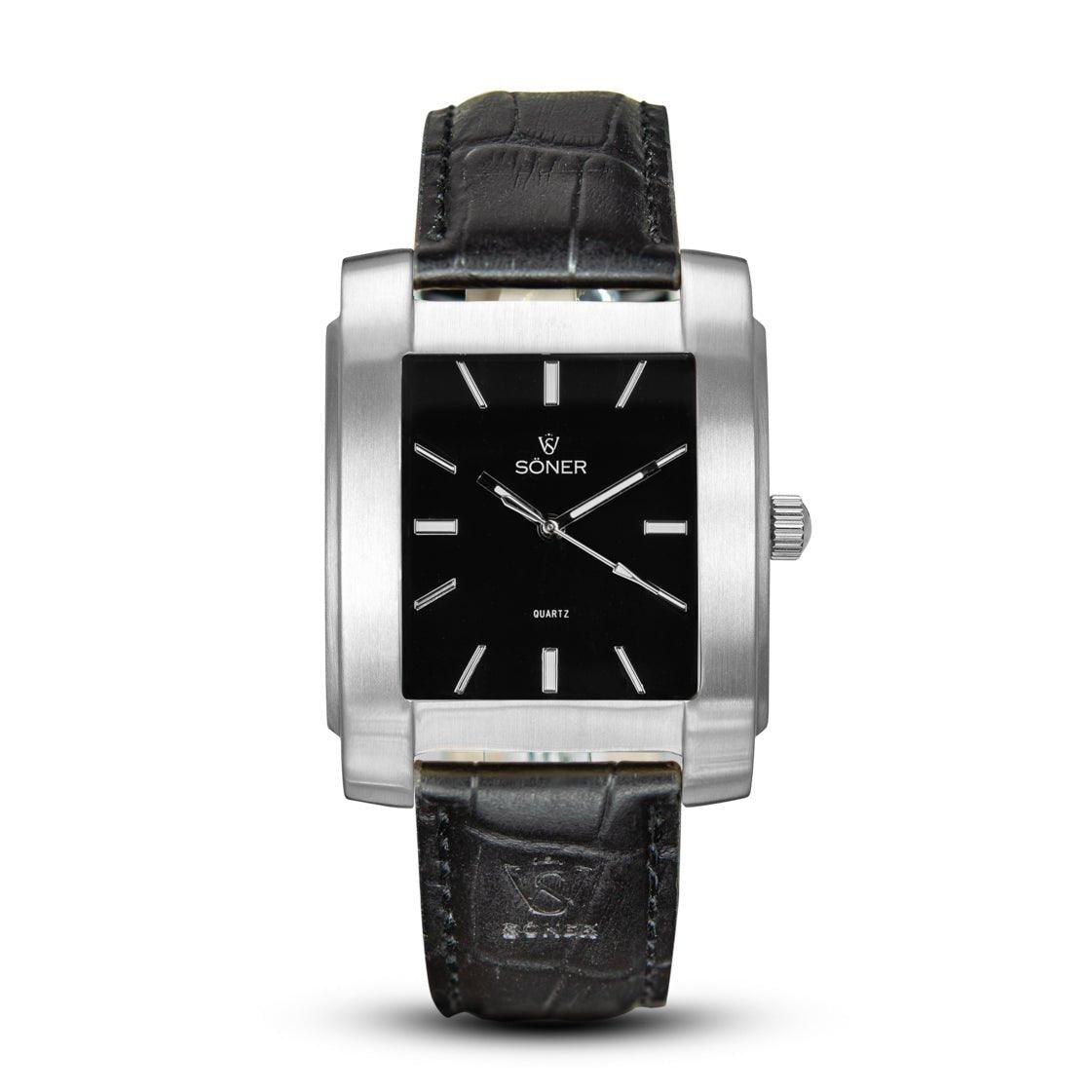 The Legacy Basilica (3-year Battery) by Söner is a stylish rectangular watch featuring a black face with silver hour markers and a sleek silver case. It comes with a textured black leather strap, and the watch face prominently displays the brand logo along with "SONER" at the top.