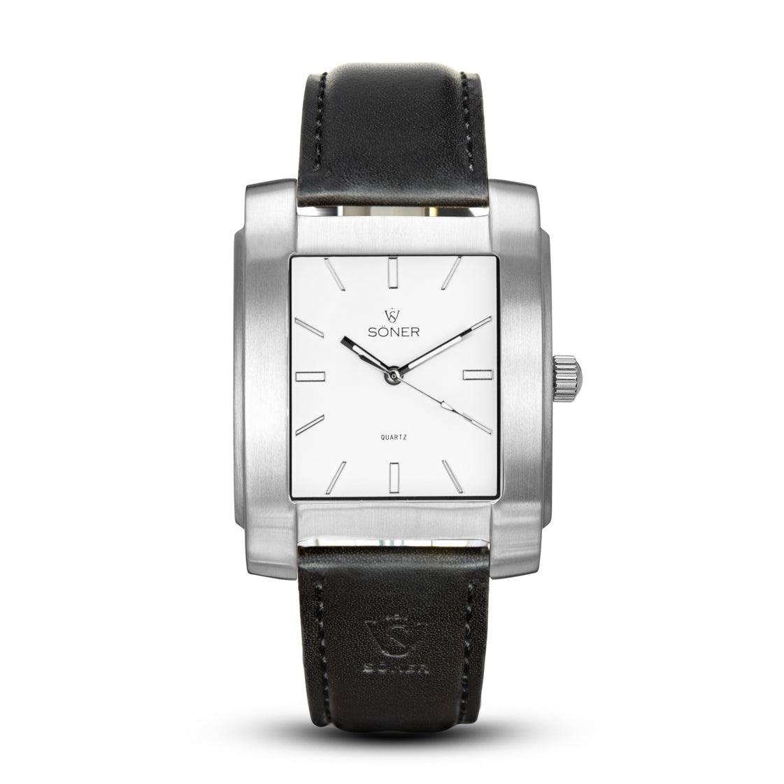 The Legacy Chaillot from Söner Watches is a sleek, rectangular wristwatch featuring a white face, silver casing, and black leather strap. It includes minimalist hour markers and hands, with "Soner" and a logo elegantly displayed on the dial. Plus, it boasts a 3-year battery life.