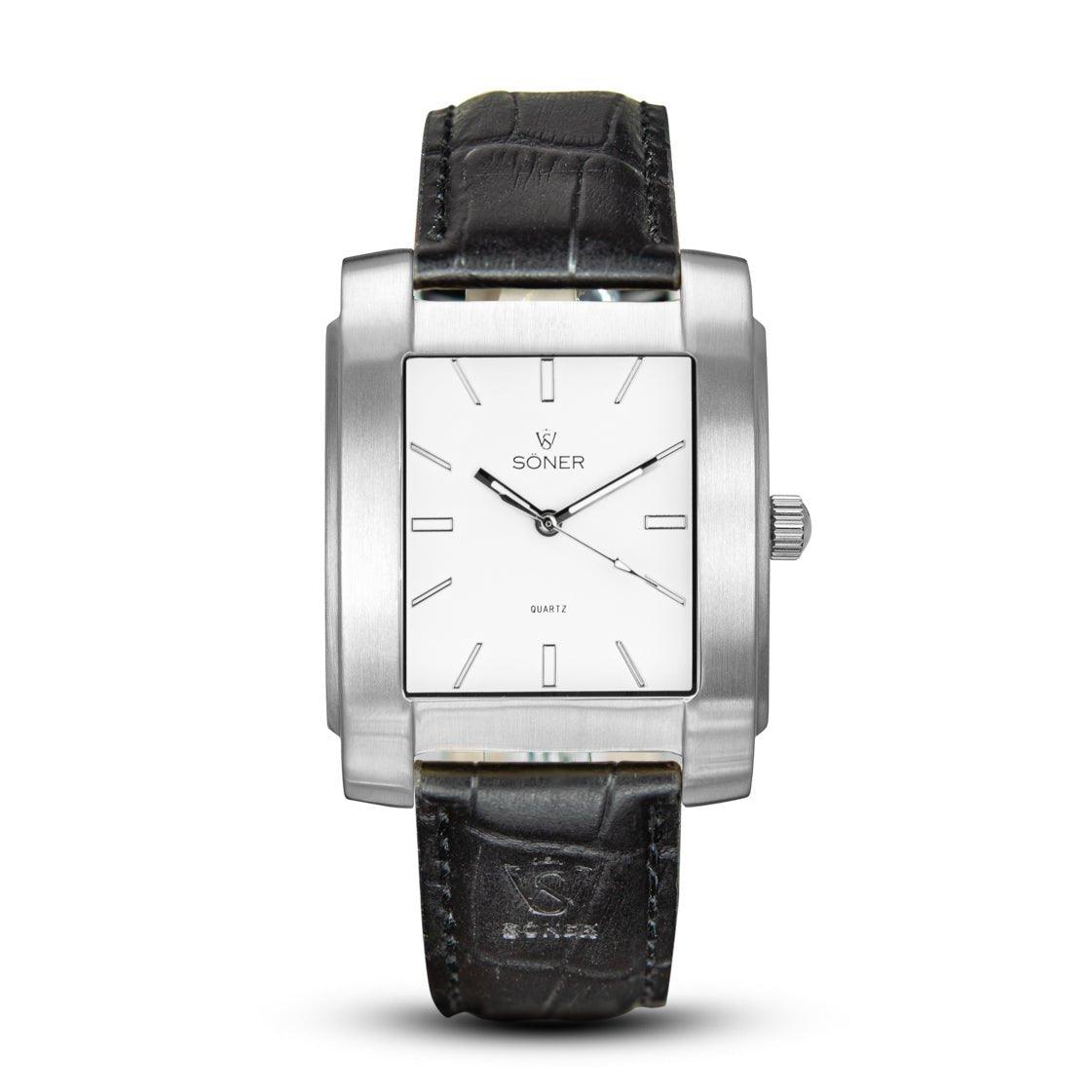 The Legacy Chaillot from Söner watches is a rectangular timepiece that features a silver case and a white face adorned with hour markers and two hands. It includes a sophisticated black leather strap with a textured pattern. The elegant design prominently displays the Söner brand and Quartz on its face.