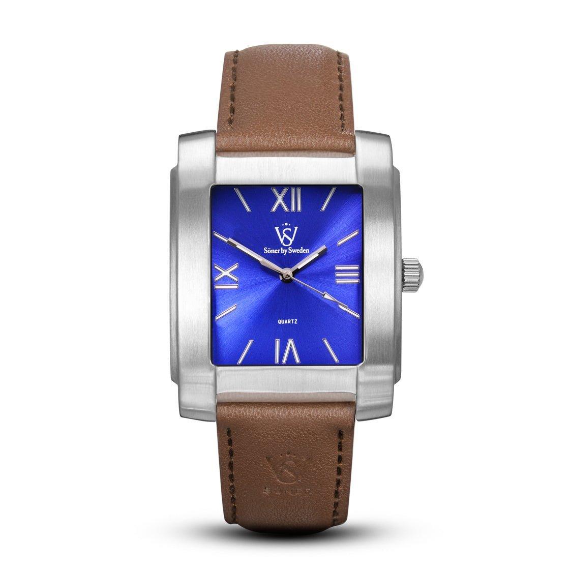 The Legacy Stoclet (3-year Battery) watch boasts a sleek rectangular design with a silver case and a bold blue dial embellished with Roman numerals. It features elegant brown leather straps and sophisticated silver hands, capturing timeless style in every detail.