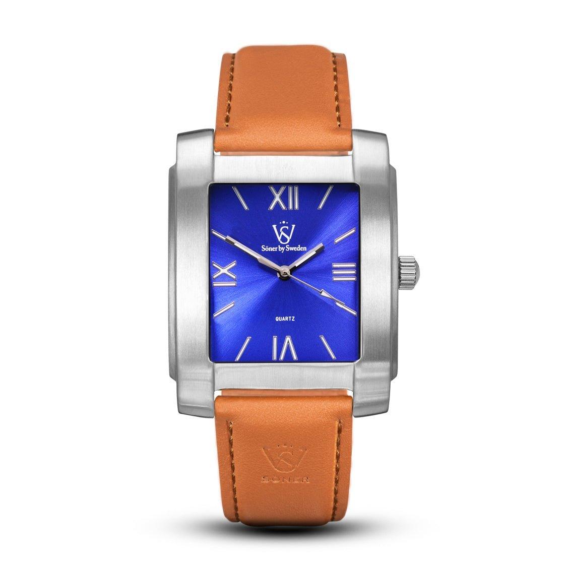 The Legacy Stoclet by Söner features a square design with a stainless steel case and a blue dial adorned with Roman numerals. It is elegantly paired with a tan leather strap and includes a subtle logo at the center of the dial. This watch also comes with a 3-year battery lifespan.