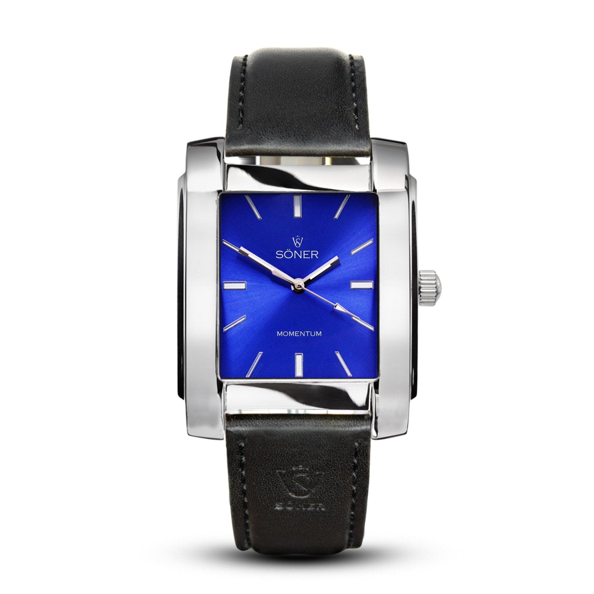 Introducing the Momentum Bacardi (Self-winding) watch, characterized by its rectangular design with a polished silver case and striking blue face. It features minimalist hour markers and sleek silver hands. The timepiece is complemented by a black leather strap with visible stitching and includes a petite crown on its right side, embodying Söner's commitment to timeless elegance.