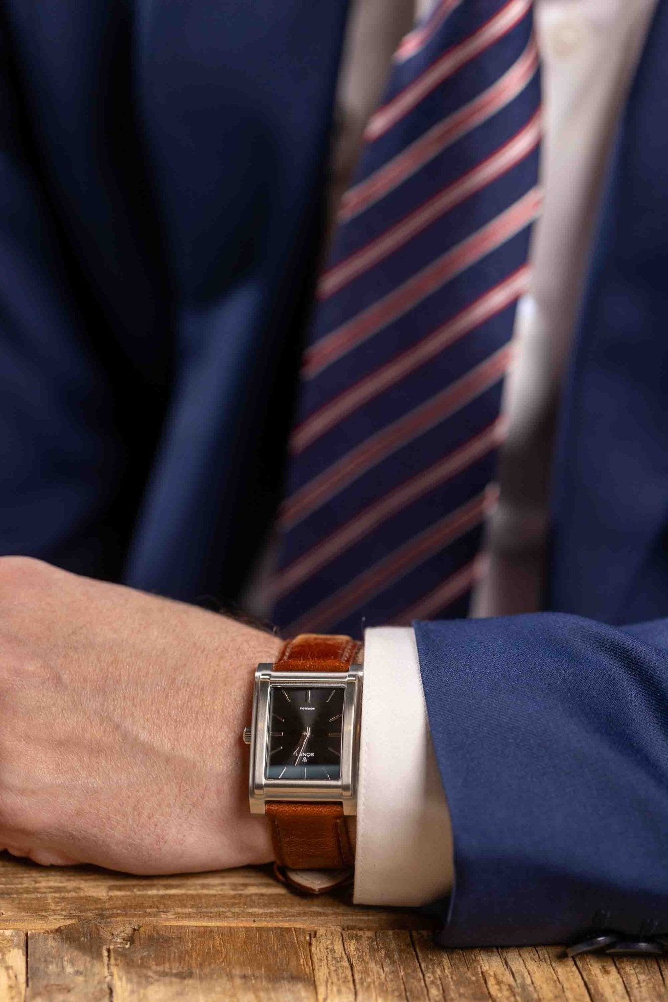 Square watch, Nostalgia London with black dial - on male wrist close up