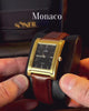 Monaco, a rectangular watch in brushed gold with a black dial vid