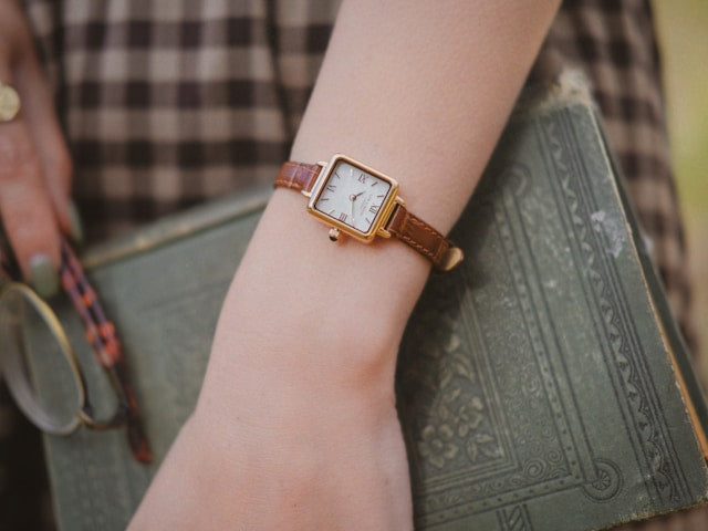 rectangular-watch-on-white-female-hand-holding-a-book