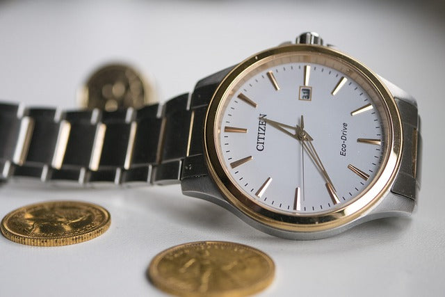 silver-citizen-wrist-watch-beside-coins